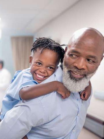在儿童医院，大胡子父亲背着儿子.